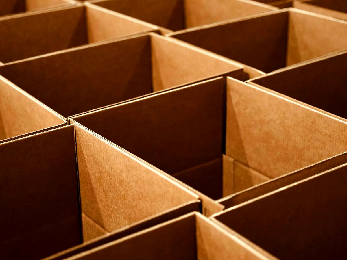 Overhead view of open kraft corrugated boxes packed edge to edge, exposing fluted-board walls.