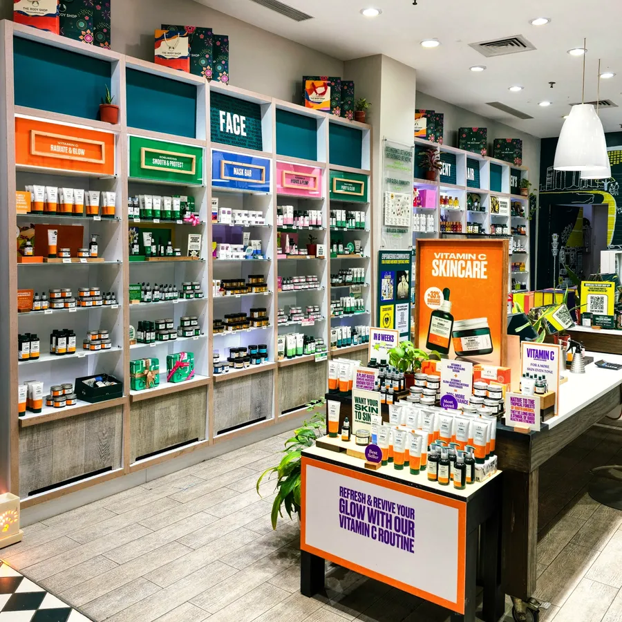 Skincare shop interior with printed cartons and bottles arranged on colour-coded shelves.